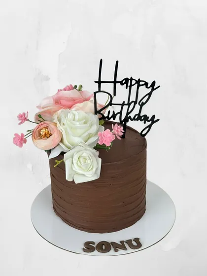 A simple yet beautiful chocolate birthday cake for Sonu. The rich chocolate frosting is perfectly complemented by a delicate arrangement of fresh flowers.