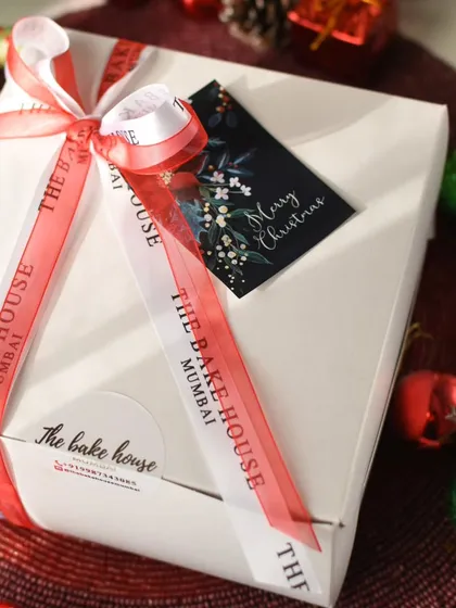 A beautifully wrapped Christmas gift box, complete with a custom ribbon and a "Merry Christmas" tag.