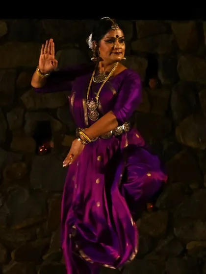 A full-figure shot against the beautiful stone backdrop of the Sunder Nursery amphitheater. The pose shows the grace and control required in Bharatanatyam, even in a static moment.