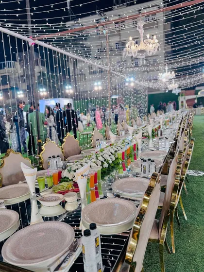 An elegant long-table dining setup for a large corporate event. The mirrored tabletops, sophisticated floral arrangements, and ambient fairy lights reflect the premium atmosphere I create.