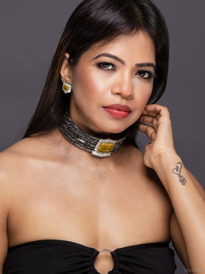 A relaxed and confident portrait of the model, showing her tattoo and the choker.