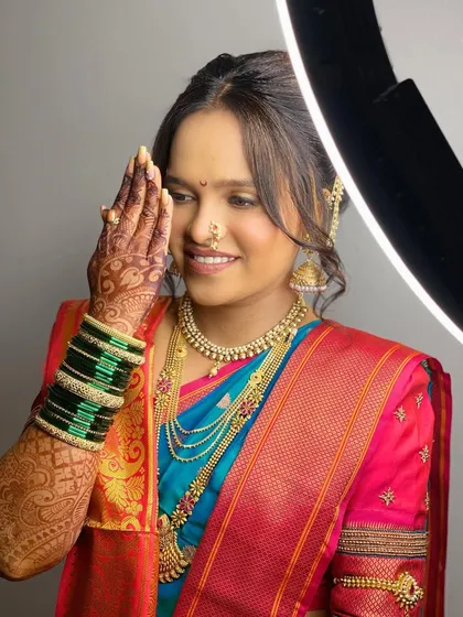 A happy bride posing with her ring light. This shot captures the flawless finish of her HD makeup, designed to look perfect both on and off camera.