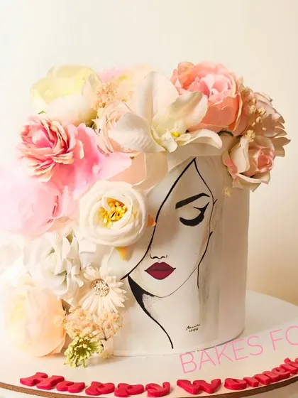 A tribute to women, this cake features a hand-painted face and a crown of fresh, beautiful flowers. It’s an artistic and empowering design, perfect for celebrating Women's Day or a special woman in your life.