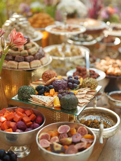 A close-up of the grazing table, featuring a cheese board, fresh and dried fruits, and various dips.