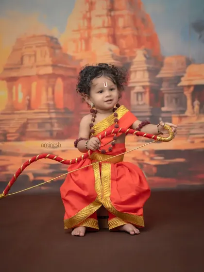 Bring the epic of Ramayana to life with my Ram Navmi theme. I provide the complete costume for your little Rama, including the dhoti, rudraksha beads, and a bow, set against a temple backdrop.