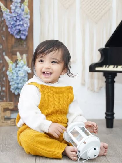 A happy, smiling baby boy enjoying his first birthday photoshoot in our studio.
