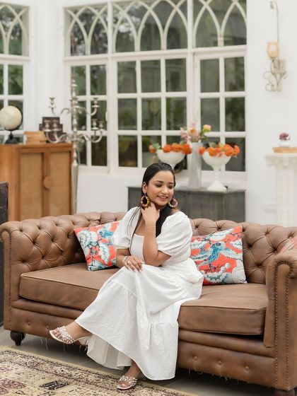 A relaxed and happy moment from a pre-wedding shoot. The makeup is minimal and fresh, perfect for a casual, sunlit scene in a white dress.