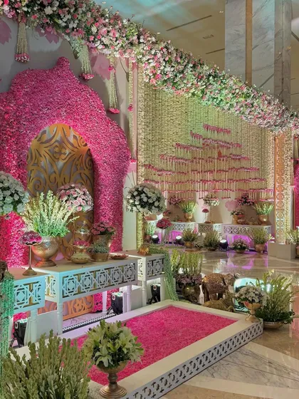 A wider view of the photo corner, showing the cascading floral wall and the lush arrangements that create a truly grand and immersive experience.