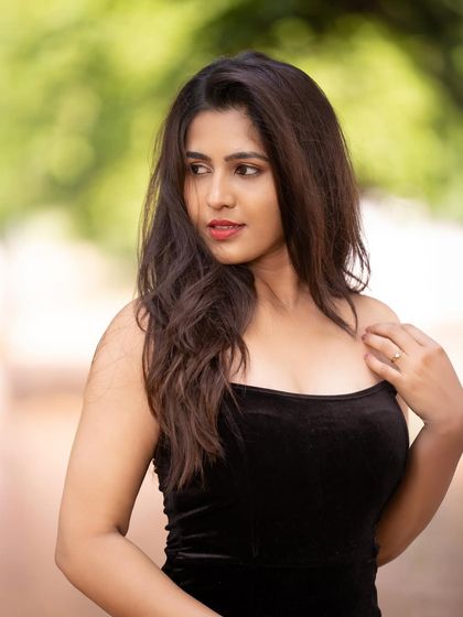 A softer portrait of Apurva, capturing a moment of quiet elegance amidst the trees.