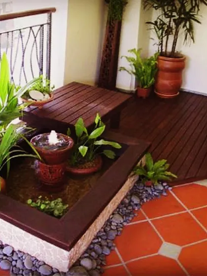 For this balcony, I designed a custom, built-in water feature with multiple tiers for plants. This setup, combined with wooden deck flooring, creates a natural and immersive oasis.