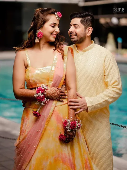 A lovely portrait of the couple at their Haldi ceremony. Their coordinated yellow outfits and happy expressions are perfect.