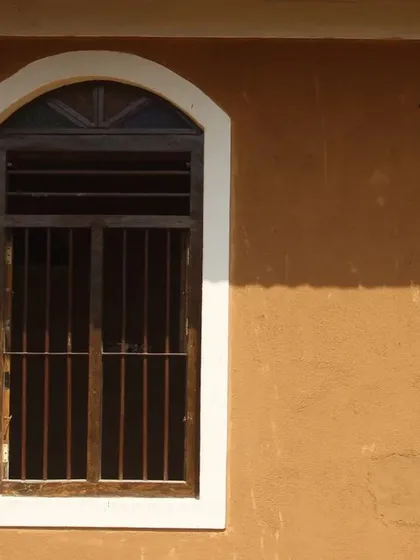 An arched window set against the smooth mud plaster of the Doddaballapura house. The simplicity of the form and the natural texture of the wall create a timeless and elegant aesthetic.