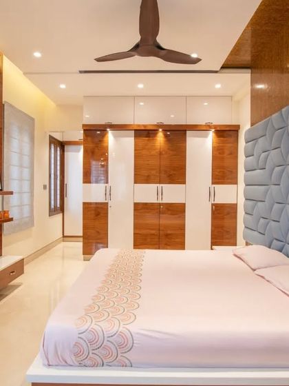 This bedroom uses a bold, 3D-paneled headboard in blue, contrasted with warm wood tones for a modern and dynamic look.