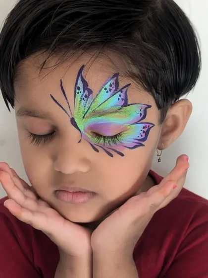 This intricate butterfly design is one of my most requested pieces for children's parties. I use multi-color cakes and fine brushes to create this beautiful, blended effect that looks magical when kids flutter their eyes.