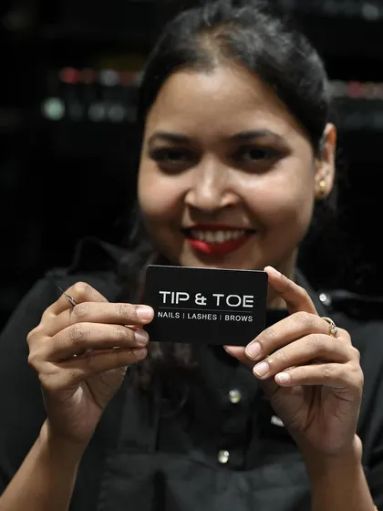 Another happy member of my professional team, holding the card that represents our commitment to quality in nails, lashes, and brows.