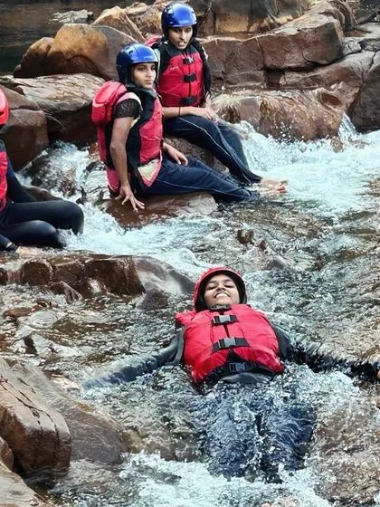 A participant relaxes in a small cascade, a refreshing and fun part of our river expeditions in Dandeli.
