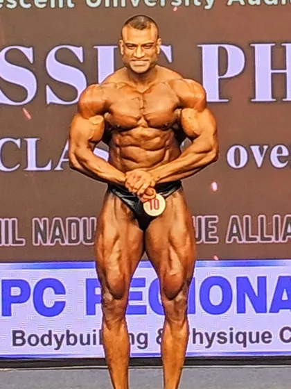 The "most muscular" pose, hands clasped variation. This pose brings out the traps, chest, and shoulder density.