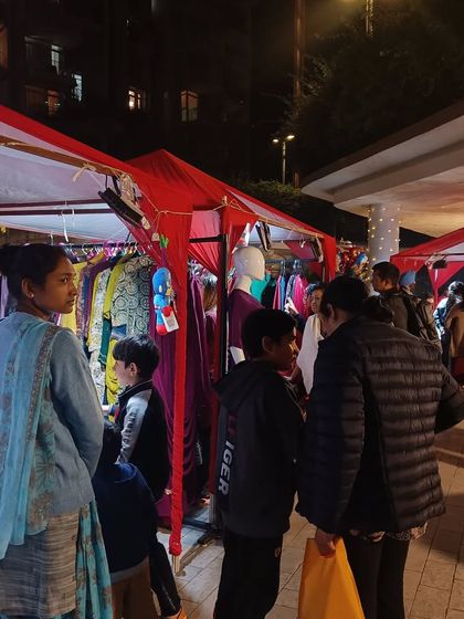 An evening shot of our outdoor exhibition, with stalls lit up and families enjoying a winter shopping experience.