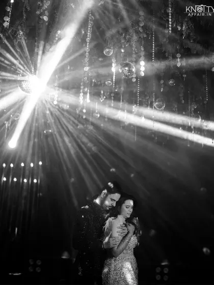 A dramatic black and white shot from the Sangeet night, using creative lighting to capture the couple's connection on the dance floor. This highlights our artistic approach and skill in creating cinematic, high-contrast images.