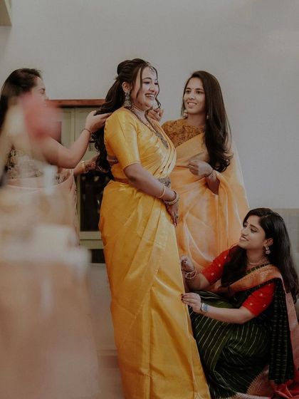 A candid shot of the bride and her friends sharing a happy moment during the engagement ceremony.