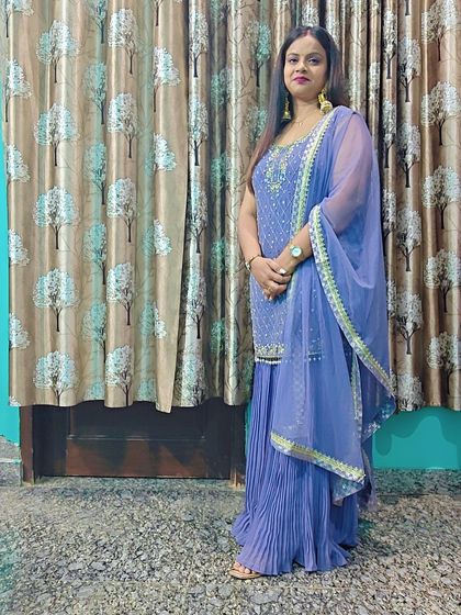 A full-length shot of the client in the lavender sharara suit.