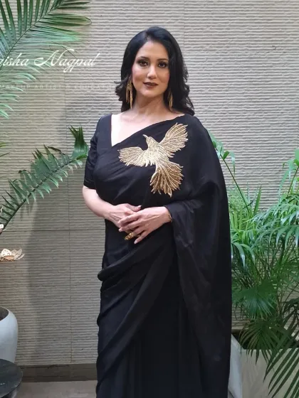 A full-length shot showcasing the complete look. The makeup perfectly complements the elegant black saree, creating a cohesive and head-turning ensemble.