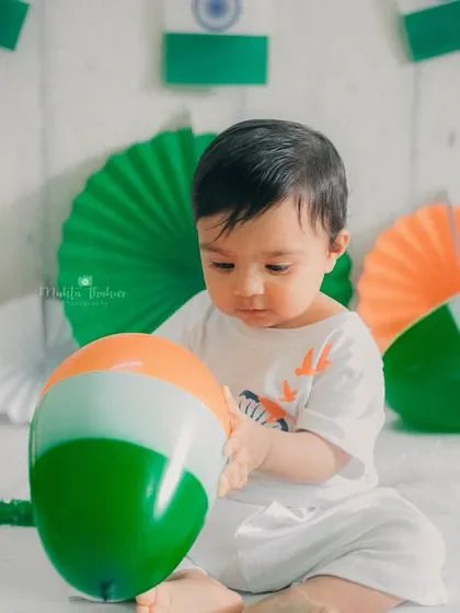 Playing with a tricolor balloon, this little one is having a great time during his Independence Day photoshoot.
