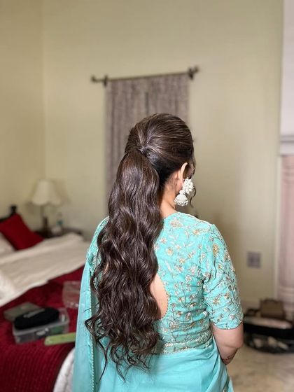 A messy ponytail with lots of volume and soft waves, perfect for a pre-wedding event.