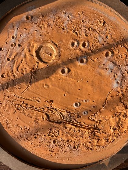 The raw, textured base of the Mars lamp drying in the sun. The shadows highlight the depth of the craters and surface details I sculpted into the paste.