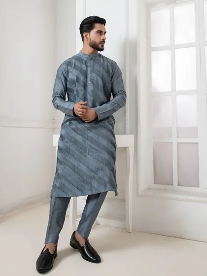 A full length view of the grey pintuck kurta. Paired with tailored trousers and black loafers, it creates a monochromatic look that is both sharp and sophisticated.