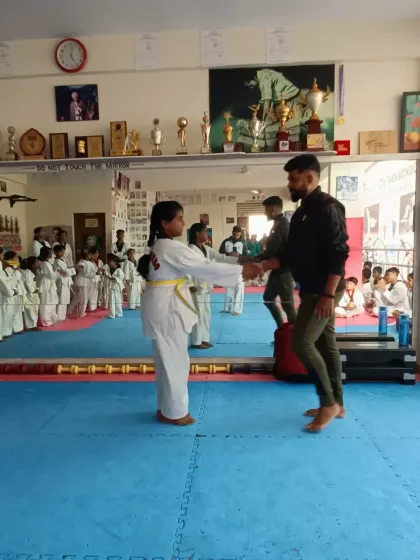 A student receives her yellow belt.