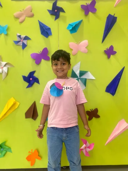 This student proudly wears his craft project. We encourage children to take pride in their creations, building their self-esteem.