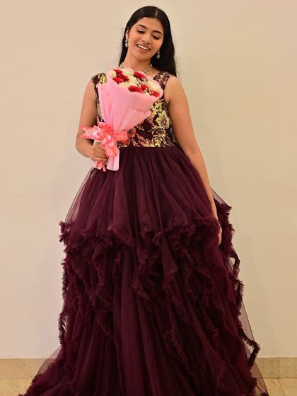A beautiful model in a deep purple gown for the awards program fashion show. The makeup is elegant and sophisticated.