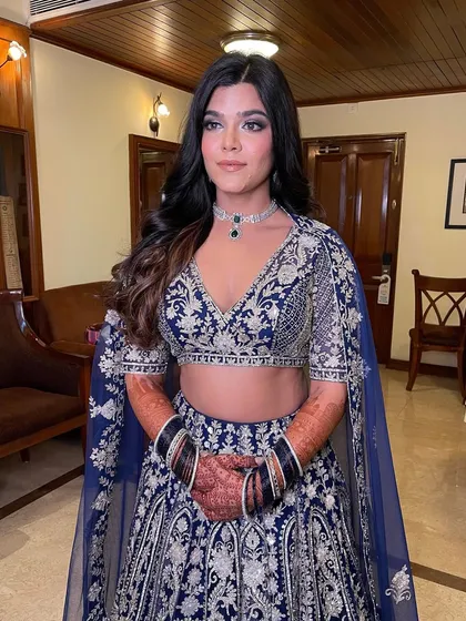 The client looking stunning in her blue sangeet outfit with her hair in soft, open waves.