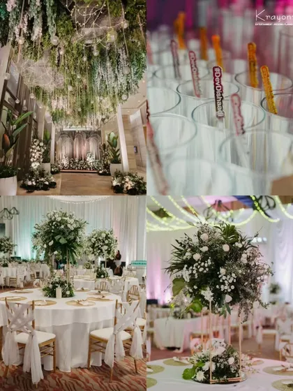 A look at the beautiful reception decor, featuring lush green and white floral arrangements, elegant table settings, and personalized drink stirrers.