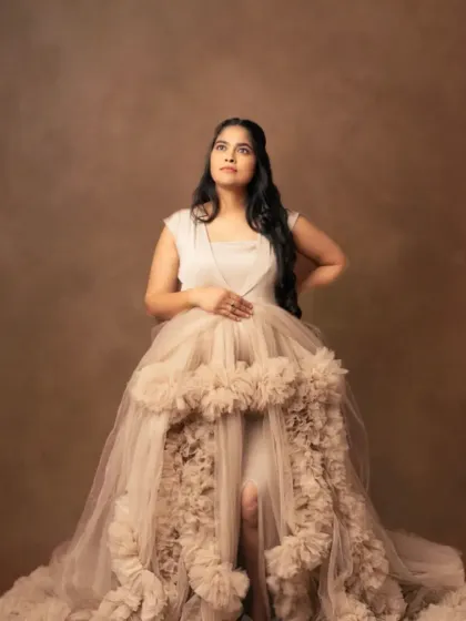 Regal and poised in our beige ruffled gown. The high-low cut and dramatic train create a look of pure sophistication.