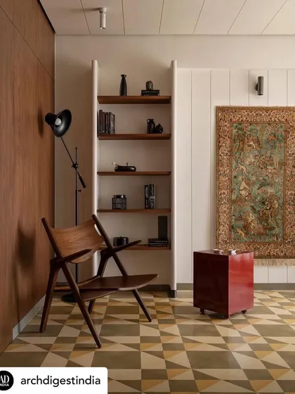 Featured in Architectural Digest, this study nook in Apartment 1005 showcases our 'Indian yet minimal' approach. A classic wooden chair and a vibrant rug are set against geometric flooring, creating a cherished enclave within the family home.