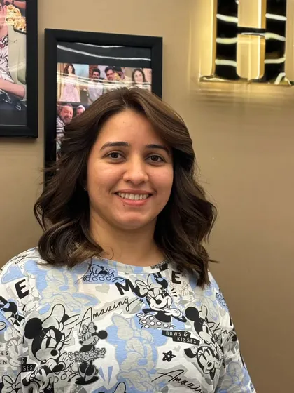 A smiling client, radiating confidence after her hair transformation. The new cut and color perfectly complement her.