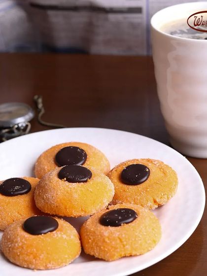 Our Orange Sugar Cookies with a chocolate button center. These buttery cookies have a hint of citrus flavour and a satisfyingly sandy texture.