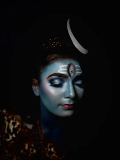 A serene, eyes-closed pose that highlights the flawless blue base and the precision of the forehead markings in this Mahadev makeup look.