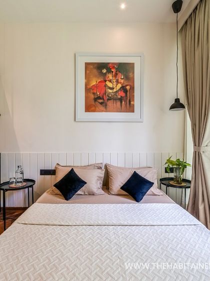 The bedroom of a 240 sq. ft. prefab pod at Pinaakini Farmstay, featuring stylish art and comfortable furnishings.