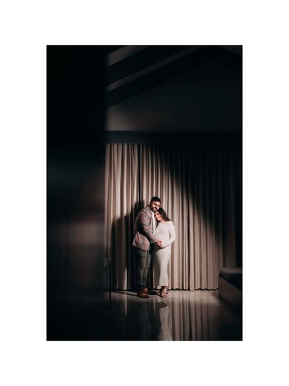 A dramatic and artistic couple's portrait using focused light in a dark studio setting. This creates a moody and intimate atmosphere, highlighting their connection.