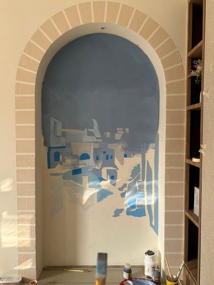 An early stage of the Santorini mural. The process starts with building up layers of color to create the foundation of the landscape before adding finer details.