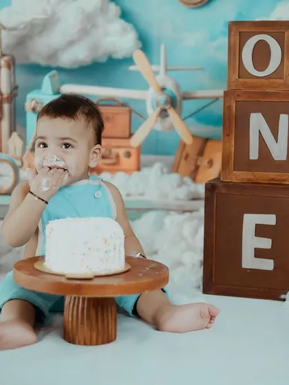 A candid shot of a happy baby enjoying every last crumb of his birthday cake. The joy on his face is what cake smash photography is all about.
