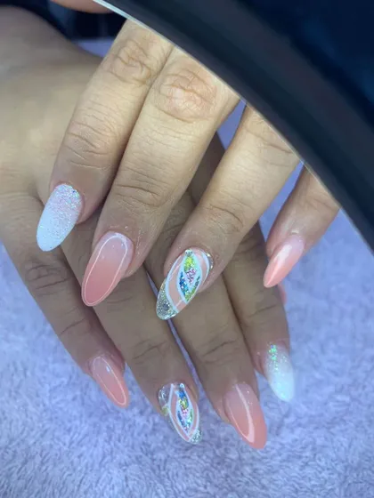 A soft and feminine set with a peachy pink base, white ombre tips, and encapsulated floral glitter accents.