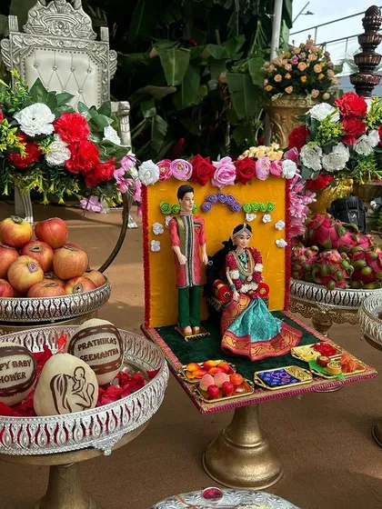 A personalized offering for a baby shower, with custom-carved coconuts and dolls representing the couple.