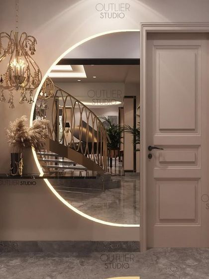 A circular, backlit mirror in this hallway creates an intriguing design moment. It offers a framed reflection of the spiral staircase in the adjoining space, turning a simple view into a piece of living art.