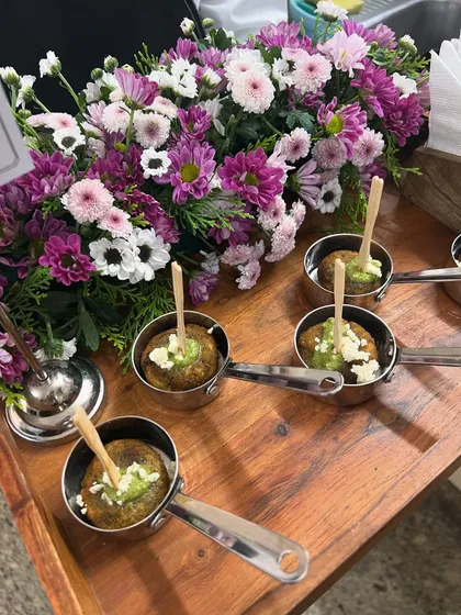 Dahi Kebabs served in individual mini pans, topped with green chutney and crumbled feta. This presentation is perfect for cocktail hours, ensuring each guest gets a perfectly assembled bite.