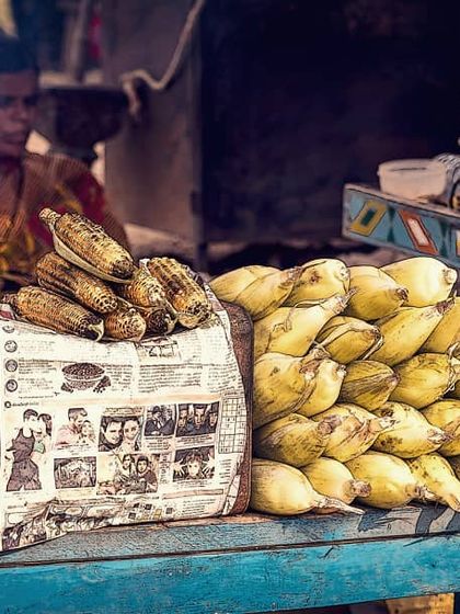 A street vendor sells roasted and fresh corn from her cart in Hampi. This photo captures the textures and colors of a typical market scene, showing a slice of everyday life and local culture.
