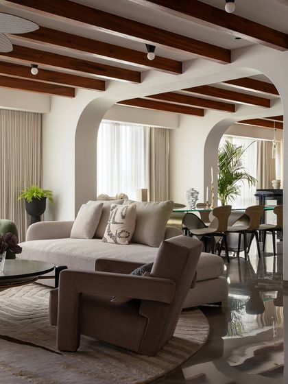 What dreams are made of. The glossy floor reflects the light and the carefully chosen furniture, including the geometric armchairs and soft sofa, creating a moody, eclectic, and deeply aesthetic living space.